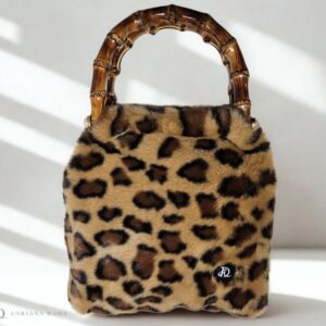 Scopri l'esclusiva borsetta animalier con manici in bambù. Fatta a mano, compatta e raffinata. Una it-bag versatile per ogni tua occasione.