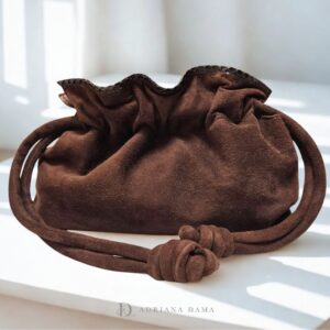 Scopri la raffinata borsa clutch in camoscio. Fatta a mano, con tracolla dorata e chiusura a coulisse. Un modello it-bag versatile per ogni look